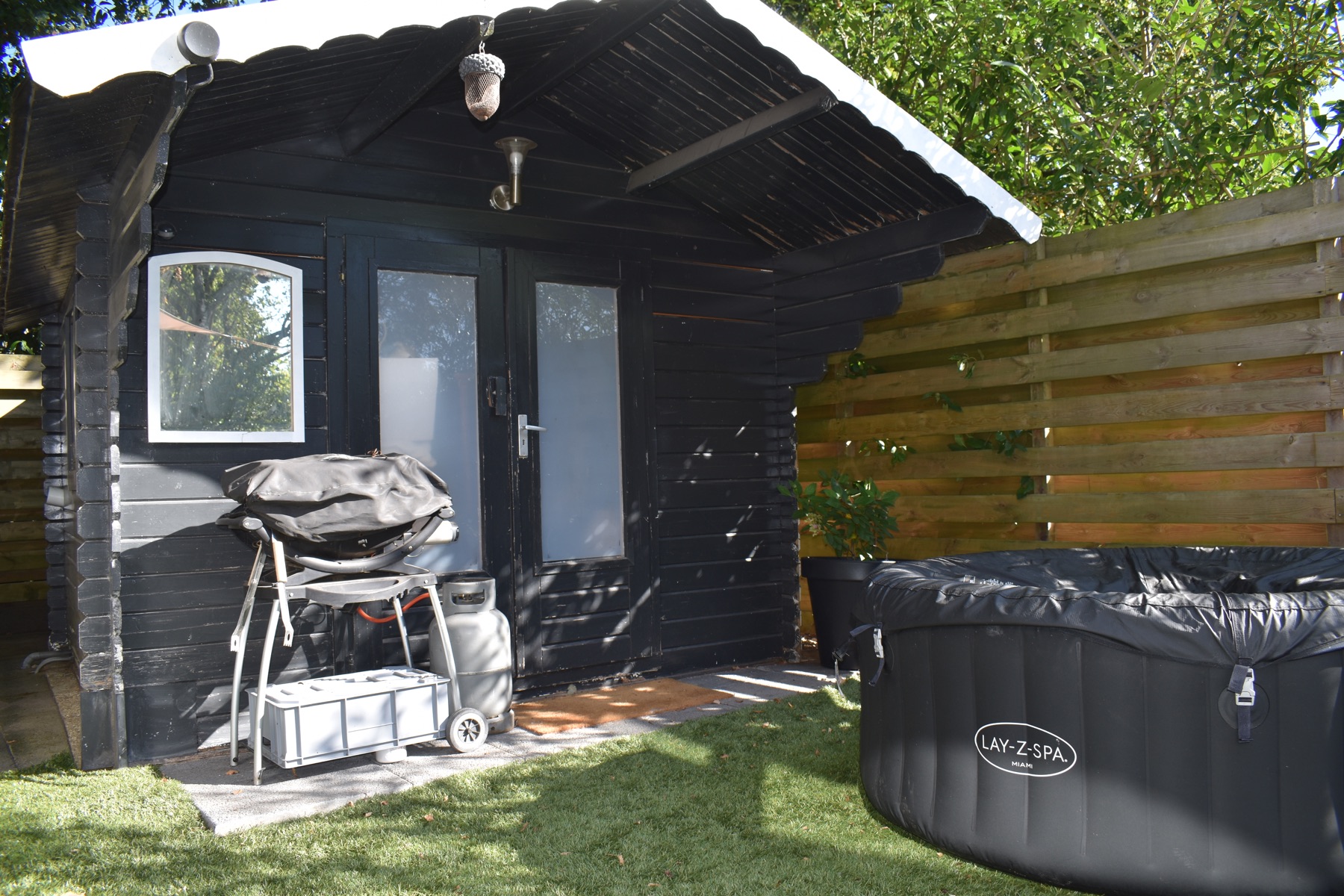 Het donkere houten chalet tussen het groen